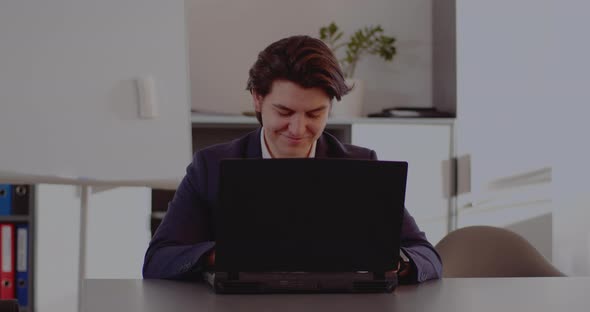 Happy Businessman Using Laptop in Office alt