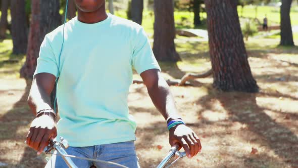Man with headphones riding bicycle in the park 4k alt