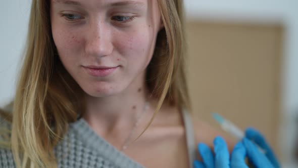Closeup Portrait of Teenage Caucasian Girl Getting Covid19 Vaccine Shot in Vaccination Center alt