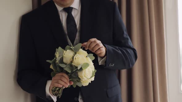 Groom with Wedding Bouquet in His Hands at Home Preparing to Go to Bride Closeup Slow Motion alt