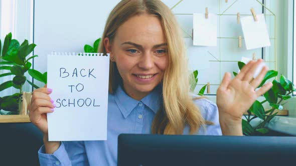 Young Female Teacher Sitting at Desk and Using Laptop at Home alt