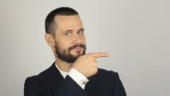 Young Successful Businessman Shows His Forefinger To the Side alt