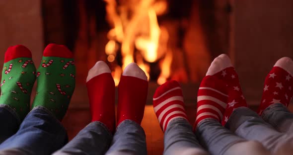 Happy family in Christmas socks near fireplace
