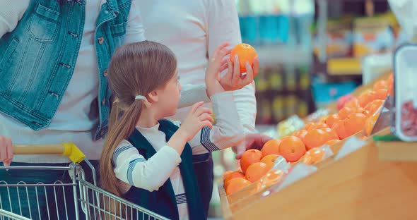 Little Girl Choosing Orange at Fruit Vegetable Supermarket alt