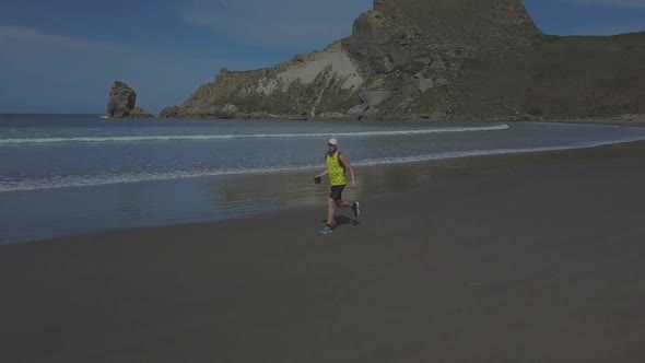 Aerial footage of runner on the beach