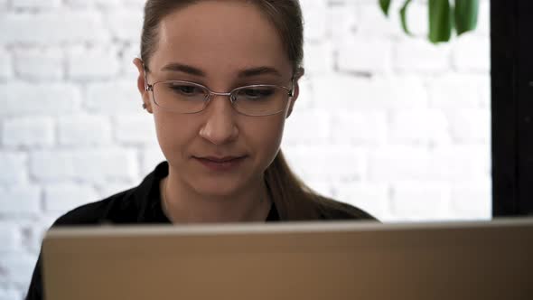 Woman In Glasses Looking on The Monitor and Surfing Internet