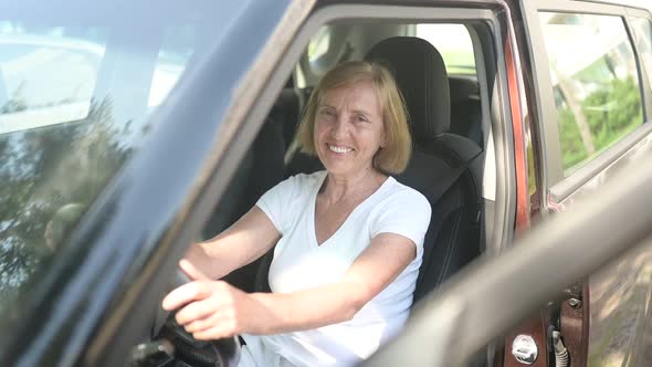 Happy Senior Woman Driving Sitting in New Brown Car Smiling Looking at Camera Enjoying Journey