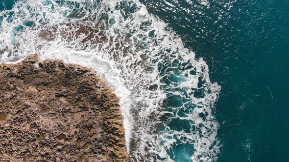  Aerial View of Sea Waves Break on Stone Beach