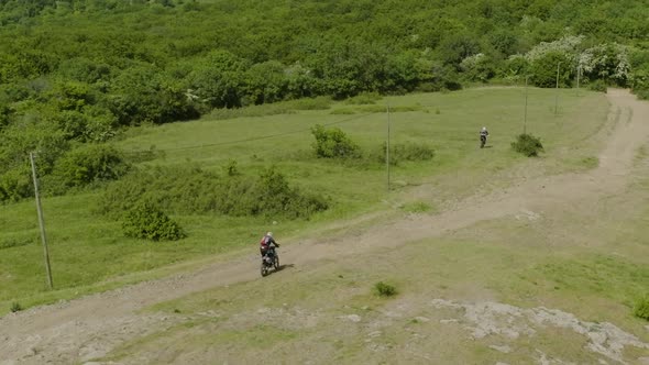 Aerial tracking shot of two motorcycles racing nearby the Junkers Memorial. alt