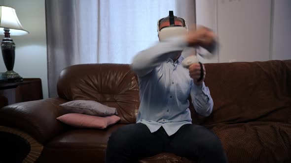 Frotn View Absorbed Man in VR Headset Imitating Boxing Gaming Online in Living Room at Home alt