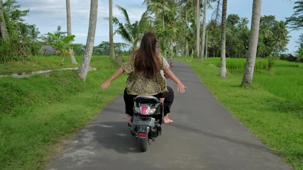 Happy couple tripping by motorcycle on tropical road at sunset time. Outdoor shot of young couple alt