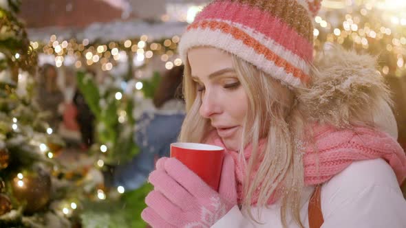 Woman in Warm Clothing with Red Cup of Hot Tea or Coffee