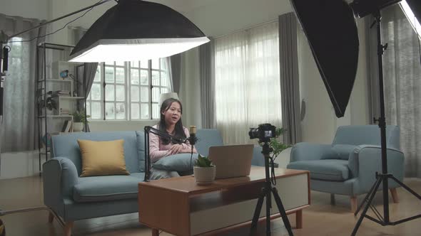 Asian Girl Vlogger Talking To Camera. Professional Light Equipment. The Girl Is Streaming alt