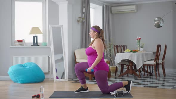 Side View of Young Obese Caucasian Woman Exercising at Home Indoors alt