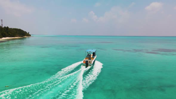 the boat sails on the turquoise-colored water surface in the Maldives near the island, which require alt