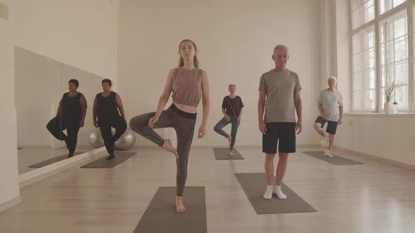 Group of People Standing on One Leg Meditating alt