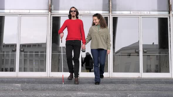 love, empathy -woman helps her boyfriend with a disability to go down the stairs alt