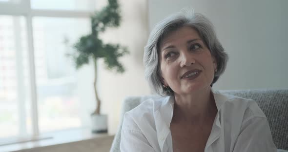 Cheerful Senior Grayish Businesswoman Laughing at Her Home Office alt
