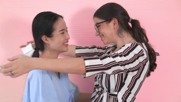 Happy Friends Take Off Face Mask and Hug Each Other Closely Together alt