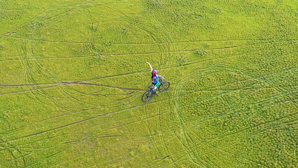 Footage B Roll 4k. Aerial view Drone tracking young People riding a bikes on the meadow