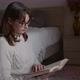 Young woman reading book in cozy room, turning page - VideoHive Item for Sale