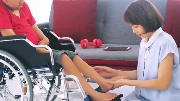 Asian mother caring for disabled son while living together at home alt