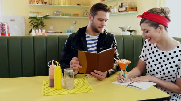 Couple looking at menu card  alt