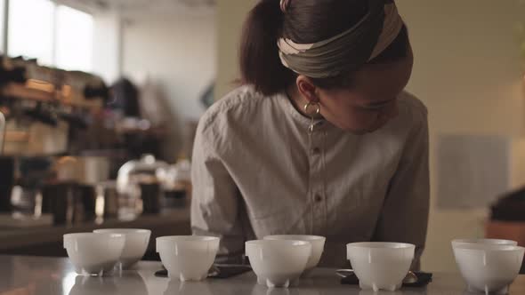 Female Barista Sniffing Different Types of Coffee alt