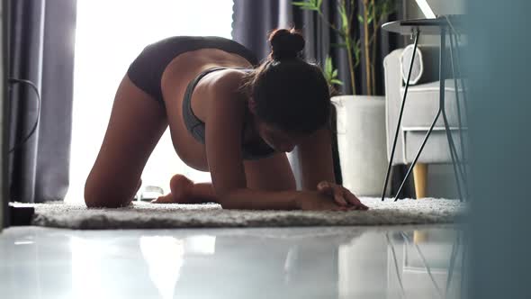 A Pregnant Woman in Her Third Trimester Doing Yoga Work Out on the Floor at Home alt