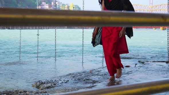 Indian Woman Walking on Banks of Holy River Ganges or Ganga at Holy City Haridwar Uttarakhand India