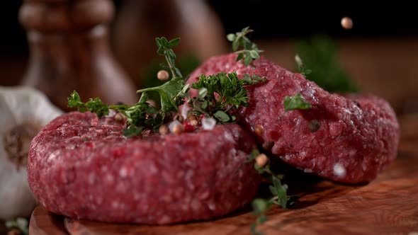 Super Slowmotion Footage of Strewing Salt and Herbs at Fresh Raw Beef Meat Burger 1000Fps alt