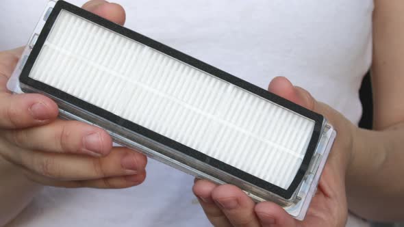 Air filter for robot vacuum cleaner close up 4k video. woman, girl, young female is holding close to alt