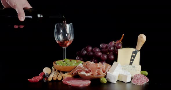 Antipasto with a Glass of Red Wine on the Table. alt