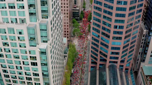 People in Orange Shirts fill the Street to Protest, High Drone Shot Moving Forward alt