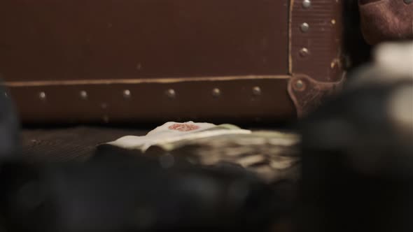 Old Money is Put on Table Next to Black Gun and Brown Leather Suitcase alt