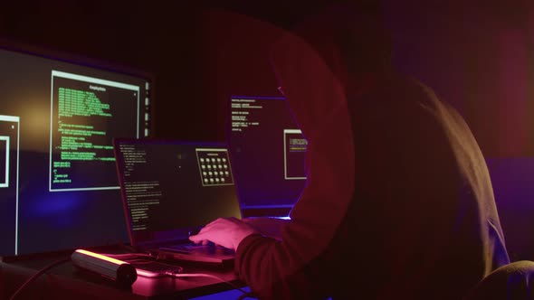 Hooded and Dark Room Hacker Hacking a Website