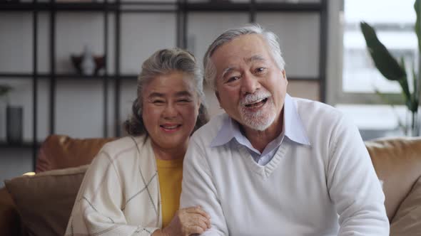 Asian mature senior couple look talk to camera at home. video calling communicate in online chat alt