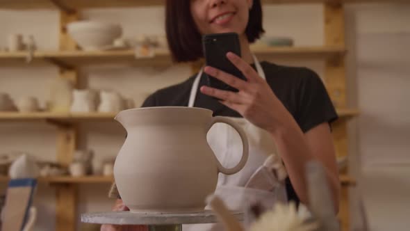 Young female potter working in her studio alt