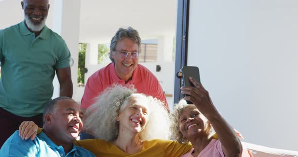 Happy senior diverse people taking selfie at retirement home alt