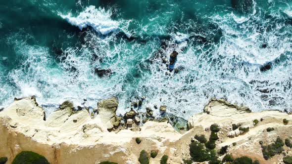 Aerial Top View  Footage By Drone of Ocean Blue Waves Break on High Cliff of a Rocky Mountain alt