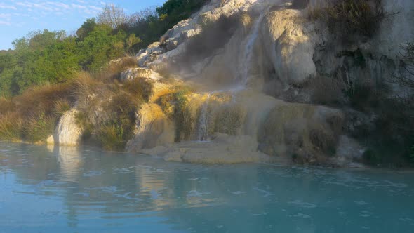 Geothermal pool and hot spring in Tuscany, Italy. Bagno Vignoni natural thermal waterfall in the mor alt