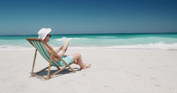 Man reading a book on the beach  alt