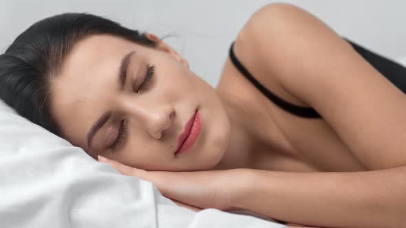 Face of Adorable Fashion Woman with Beauty Makeup Sleeping on Bed alt