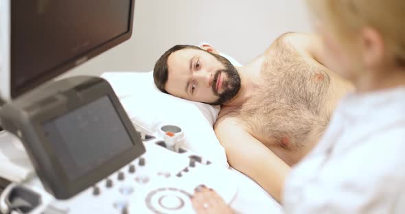 Doctor Examining Males Kedneys with Ultrasound Scan in Clinic alt