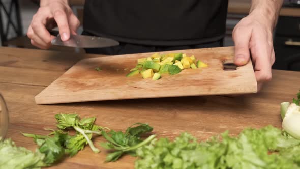 Making Green Juice at Home Male Hands Add Sliced Avocado To a Blender in the Kitchen alt