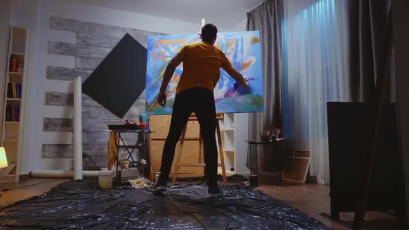 Guy Painting on Canvas with Roller alt