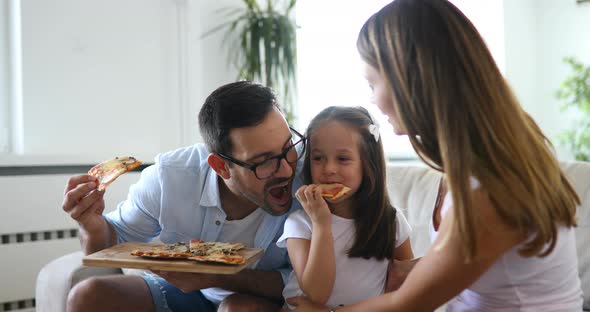 Happy Family Sharing Pizza Together at Home