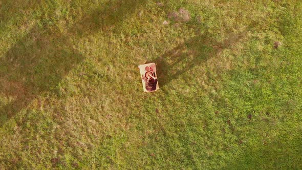 Aerial View Tilted Down of Male Potter Making Ceramic on Potter's Wheel Watering Clay and Forming alt