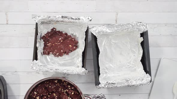 Flat lay. Step by step. Scooping melted chocolate into baking pans lined with cooking foil to make m alt