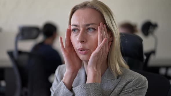 Stressed Anxious Caucasian Woman Sitting in Office Trying Calm Down with Blurred Colleagues at alt